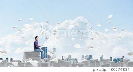 Attractive man sitting on pile of paper documents. 36274854