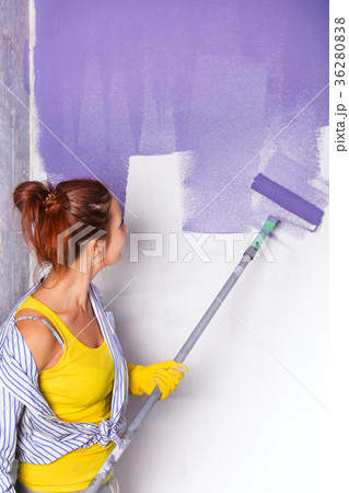 woman paints wall with purple paint roller woman paints wall with purple paint roller 36280838