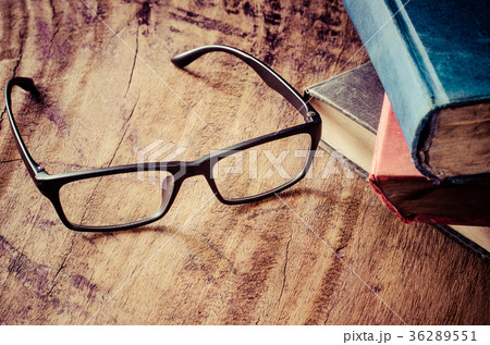 Glasses placed on a wooden table with books. Glasses placed on a wooden table with books. 36289551