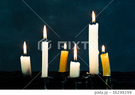 Candles on an old wooden burnt table. Candles on an old wooden burnt table. 36298299