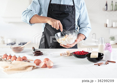A cook with eggs on a rustic kitchen against the A cook with eggs on a rustic kitchen against the 36299209