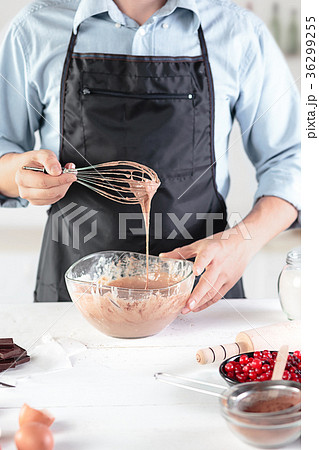 A cook with eggs on a rustic kitchen against the A cook with eggs on a rustic kitchen against the 36299255