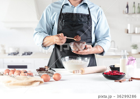 A cook with eggs on a rustic kitchen against the 36299286