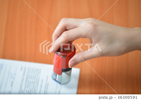 Female hand hold rubber stamps over documents and 36300591