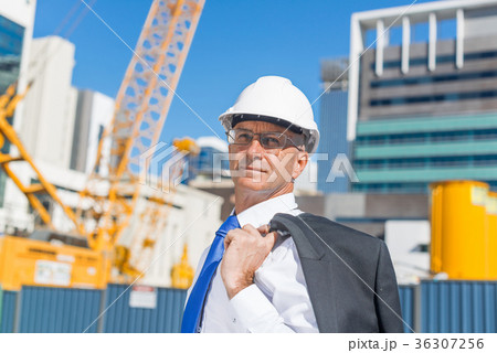 Senior elegant builder man in suit at construction site on sunny summer day Senior elegant builder man in suit at construction site on sunny summer day 36307256