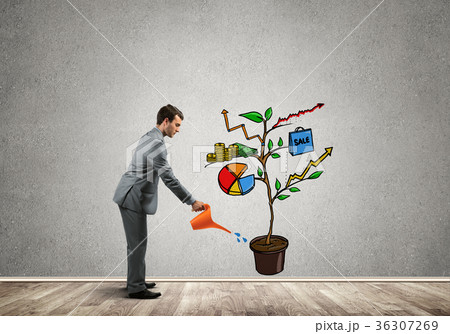 Young businessman in empty room watering drawn growth concept with can 36307269