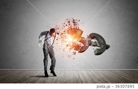 Determined banker man in empty concrete room breaking dollar figure Determined banker man in empty concrete room breaking dollar figure 36307895