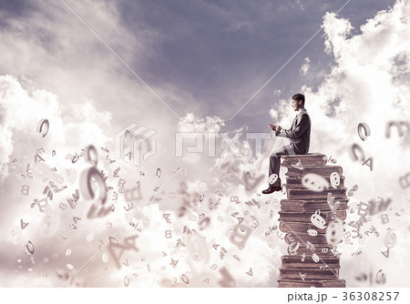 Businessman or student on book and symbols flying around Businessman or student on book and symbols flying around 36308257