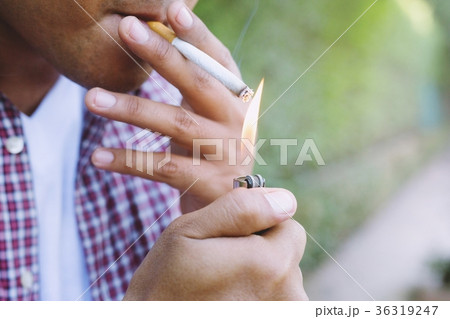 man smoking a cigarette. Cigarette smoke spread.	 36319247