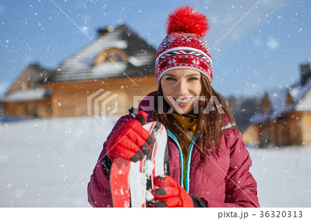 Sporty female holds snowboard in mountains Sporty female holds snowboard in mountains 36320313