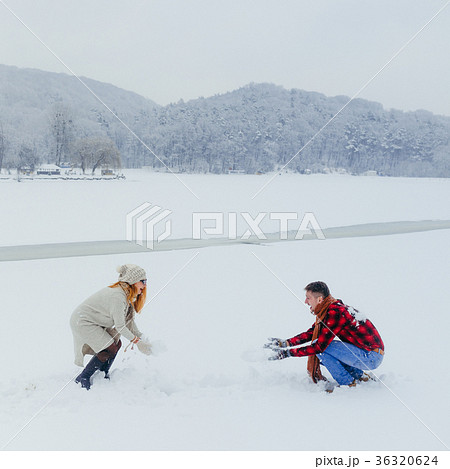 Joyful beautiful couple is playing snowballs on 36320624