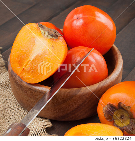 Persimmons in bowl with kitchen knife  36322824