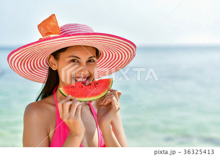 Beautiful girl wearing swimsuit eating watermelon beach. 36325413