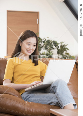 自宅リビングのソファーでパソコンをする若い女性 36329616