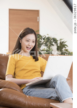 自宅リビングのソファーでパソコンをする若い女性 36329617