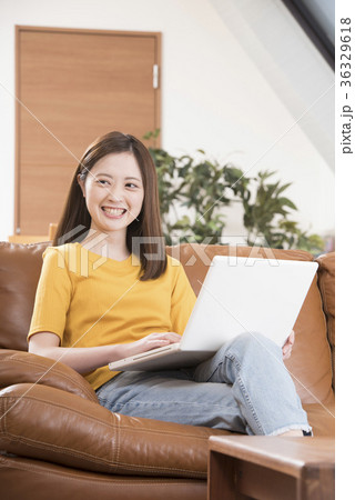 自宅リビングのソファーでパソコンをする若い女性 36329618
