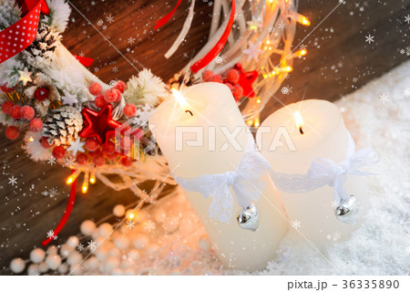 White candles on the snow with Christmas wreath 36335890