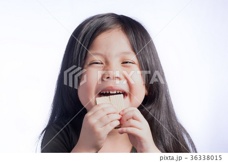 Portrait a Cute Little Asian Girl Eating Wafer on Isolate White 36338015
