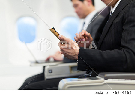 飛行機 スマホ 出張 ビジネスマン 飛行機 スマホ 出張 ビジネスマン 36344164
