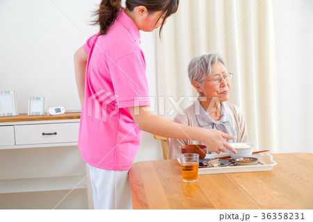 食事をする高齢者とそれを見守る介護士　少し食事を嫌がる老人　風邪　病気 36358231
