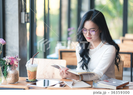 asia girl reading a book at the cafe 36359300