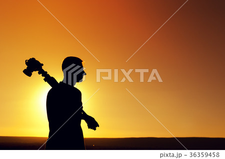 Silhouette of photo operator near sea at sunset Silhouette of photo operator near sea at sunset 36359458