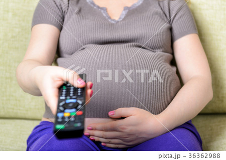Pregnant woman hand holding remote control Pregnant woman hand holding remote control 36362988