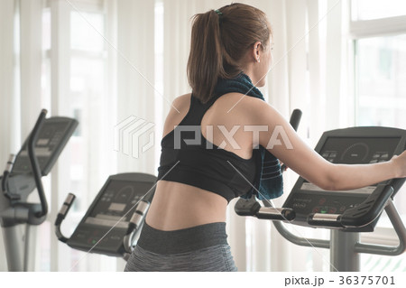 Back view of Woman working out on fitness machine 36375701