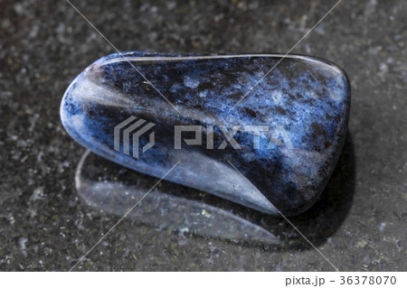 tumbled dumortierite gem on dark background 36378070