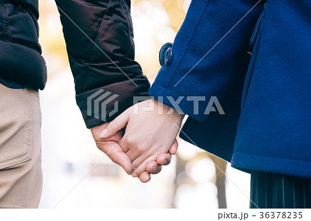 手をつなぐカップル 手元 冬のデートの写真素材