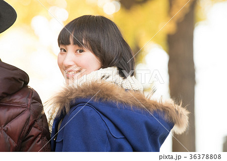 寄り添い歩く若いカップル 冬デートの写真素材