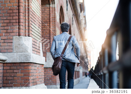 Mature businessman walking in a city. Mature businessman walking in a city. 36382191