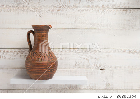 clay jug at shelf on white wooden background 36392304