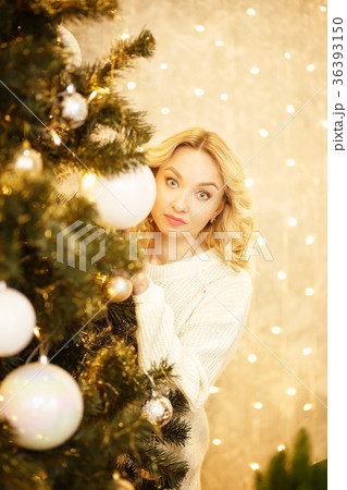 Beautiful woman with Santa hat peeking behind Beautiful woman with Santa hat peeking behind 36393150