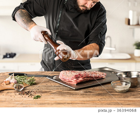 Man cooking meat steak on kitchen 36394068