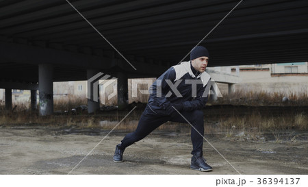 Attractive man runner doing stretching exercise 36394137