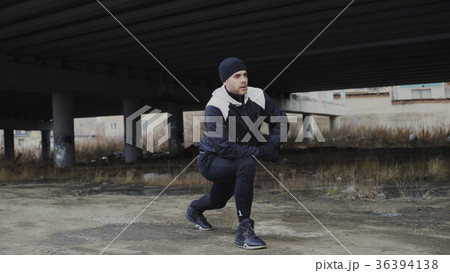 Attractive man runner doing stretching exercise 36394138