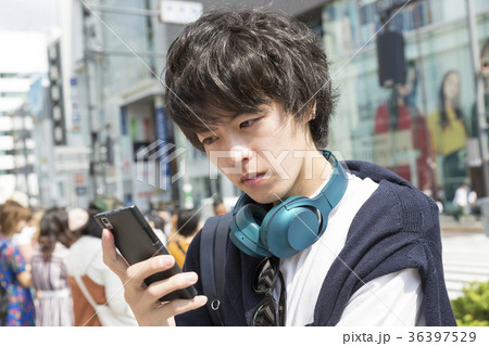 スマホを見て悩む男性　東京　原宿　神宮前交差点前 36397529