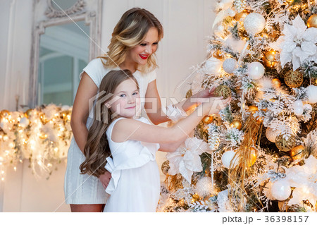 mother and daughter decorating Christmas tree mother and daughter decorating Christmas tree 36398157