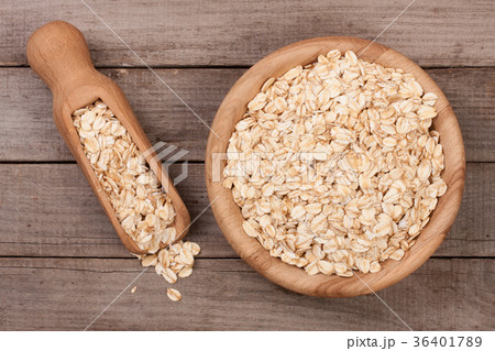 Oat flakes in a wooden bowl with a scoop on an old Oat flakes in a wooden bowl with a scoop on an old 36401789