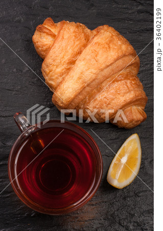 croissant with a cup of tea on a black stone croissant with a cup of tea on a black stone 36402199