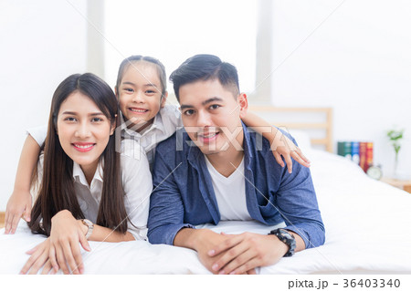 Happy asian family lying on a bed 36403340