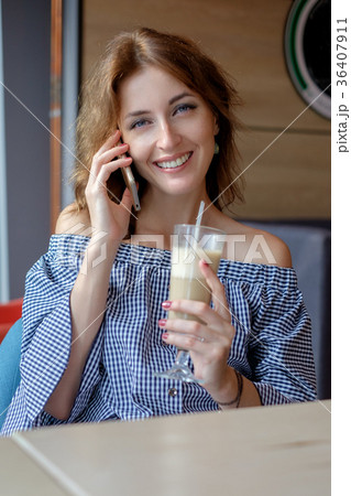 Cheerful young lady at the restaurant talking on 36407911