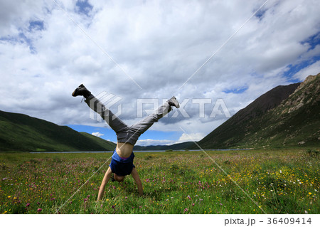 handstand woman have fun on mountain peak meadow 36409414
