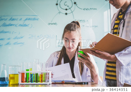 Couple of students working at chemistry class. Couple of students working at chemistry class. 36414351