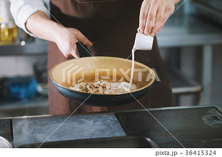 Chef is pouring the sauce into the meat 36415324