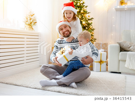 happy family father and children playing near Christmas tree happy family father and children playing near Christmas tree 36415543
