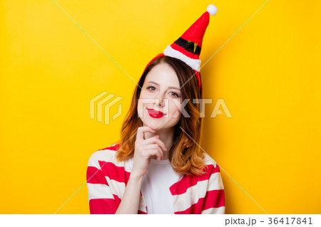 Portrait of young redhead woman in Santa Claus hat Portrait of young redhead woman in Santa Claus hat 36417841