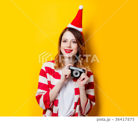 woman in Santa Claus hat with vintage camera 36417875