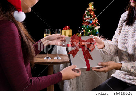 Beautiful two women holding gift boxes and two glasses with cham 36419626